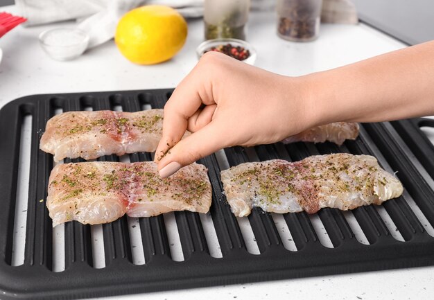 A cook applying breadcrumbs to chicken cutlets, illustrating the breading technique.